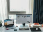 A job hunter’s guide to finding the right positions in Advertising & Marketing laptop on desk with a desktop on desk with some toys and a small plant