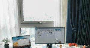 A job hunter’s guide to finding the right positions in Advertising & Marketing laptop on desk with a desktop on desk with some toys and a small plant