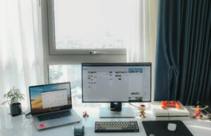 A job hunter’s guide to finding the right positions in Advertising & Marketing laptop on desk with a desktop on desk with some toys and a small plant